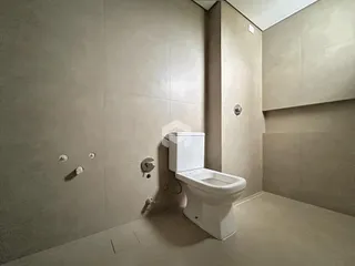 Foto de um banheiro interno com revestimento de cerâmica e vaso sanitário branco.