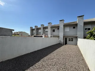 Vista da fachada de uma residência em Lajeado, Brasil, com muro e área de cascalho.
