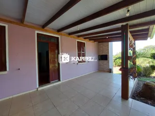 Sala de estar com piso de cerâmica e estrutura de vigas de madeira exposta.