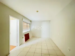 Passagem interna de uma residência com piso de cerâmica clara.