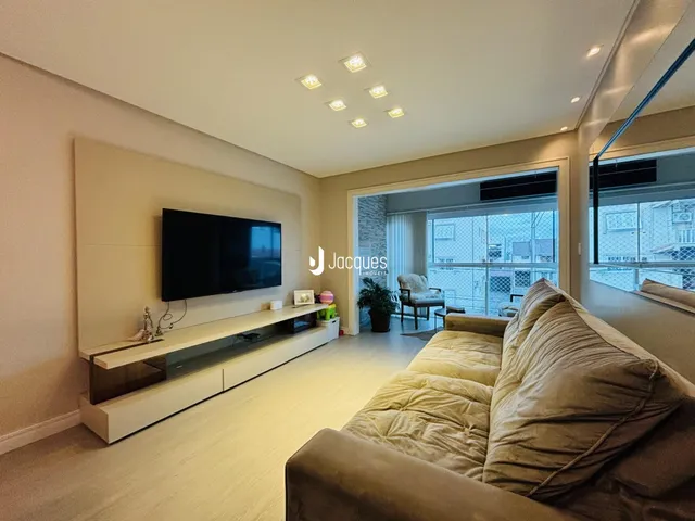 Sala de estar moderna com sofá e televisão em um apartamento.