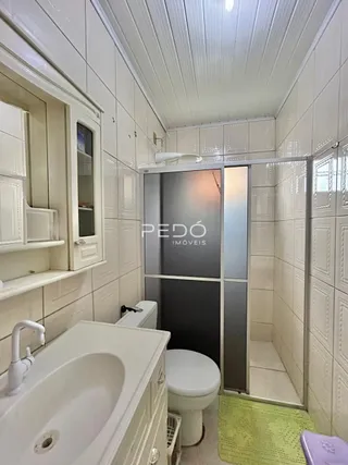 Banheiro com revestimento cerâmico e box de vidro