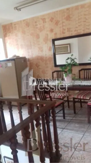Quarto com cabeceira de madeira e espelho em uma sala.