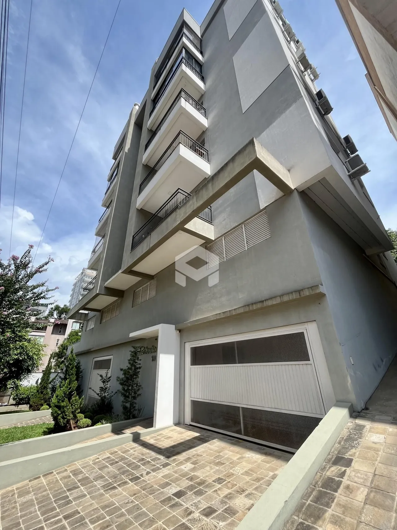 Fachada de um prédio residencial em Lajeado, Brasil com garagem e área externa.