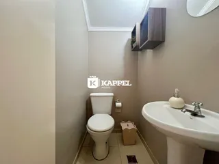 Foto interna de um banheiro com vaso sanitário e pia branca.