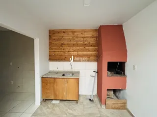 Foto interna de uma cozinha com revestimento de madeira e parede de tijolo aparente.