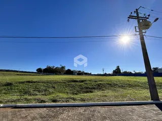 Vista de um campo gramado sob um céu azul claro.