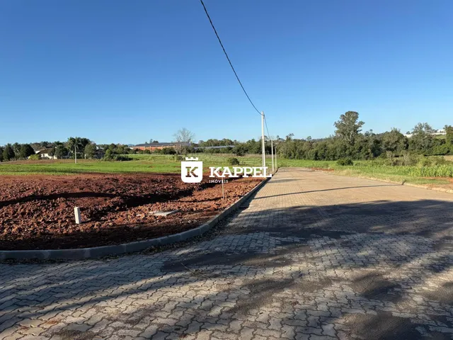 Vista externa de uma estrada de terra adjacente a um campo aberto.