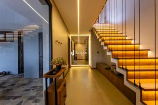 Hall de entrada com escadaria e iluminação moderna.