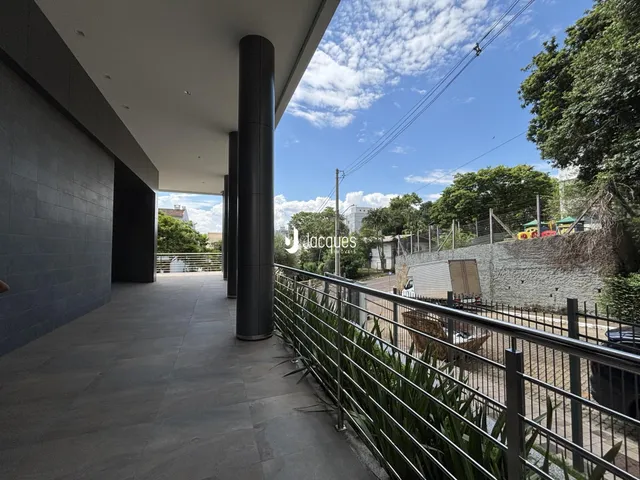 Vista de uma área externa coberta com piso de concreto e grade de proteção.