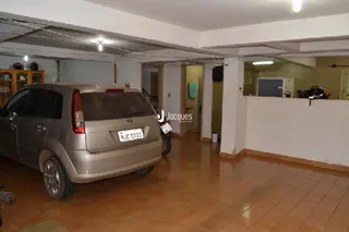 Interior de uma sala com um veículo estacionado.