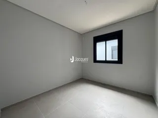 Interior de um cômodo com paredes brancas e piso de cerâmica.