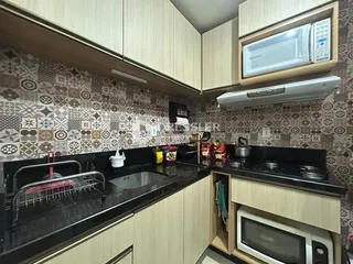 Cozinha com armários de madeira e revestimento de parede.