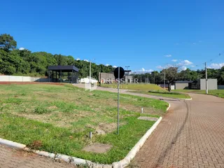 Vista externa de um terreno com gramado e caminho de tijolos.