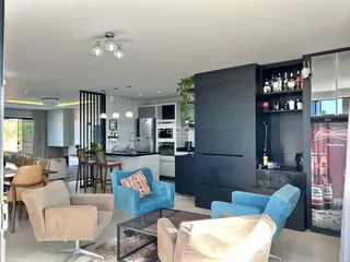Sala de estar com decoração moderna e área de jantar em um imóvel no Brasil.