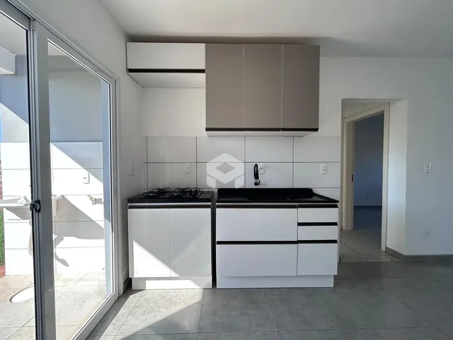 Foto da cozinha moderna com armários brancos e bancadas escuras.