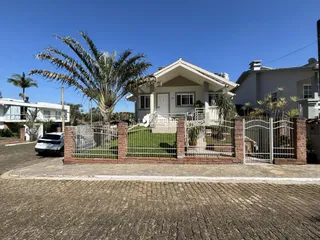 Fachada de uma residência em Lajeado, Brasil, com cerca e jardim frontal.