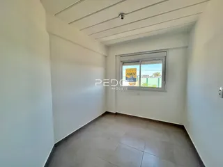 Vista interna de um ambiente com paredes brancas e piso de cerâmica.