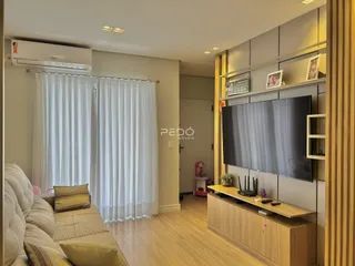 Sala de estar com sofá e televisão em um apartamento.