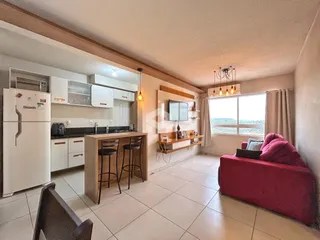 Sala de estar com cozinha aberta e vista para o exterior em Lajeado.