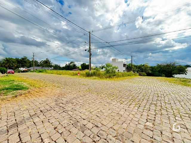 Vista da fachada da propriedade com pavimento de paralelepípedos.