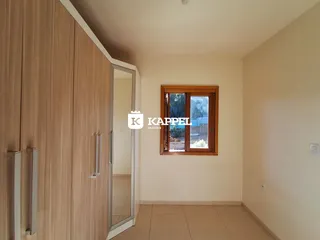 Foto de um corredor interno com armário de madeira e janela.