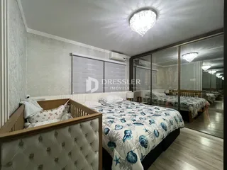 Quarto com cama de casal e portas de vidro no interior da residência.