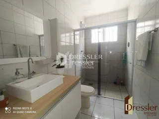 Foto de um banheiro com pia e revestimento branco.
