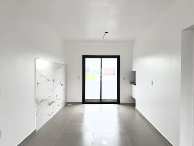 Hall de entrada com piso de cerâmica e parede de mármore na residência.