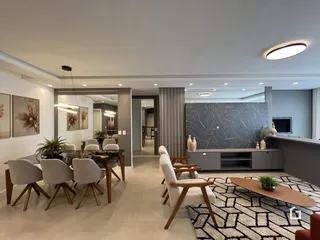 Ambiente de sala de estar e jantar moderno com decoração clara.