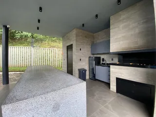 Cozinha moderna com ilha de granito e armários cinzas em ambiente contemporâneo.