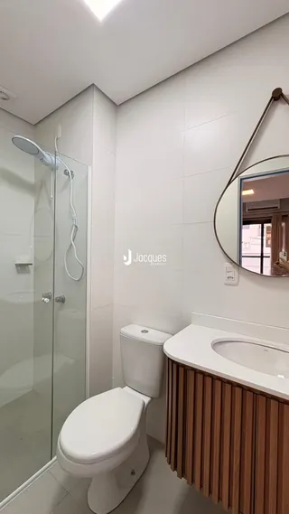 Banheiro com piso cerâmico e box de vidro.