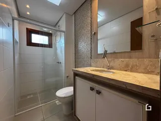 Foto de um banheiro moderno com box de vidro e bancada de mármore.