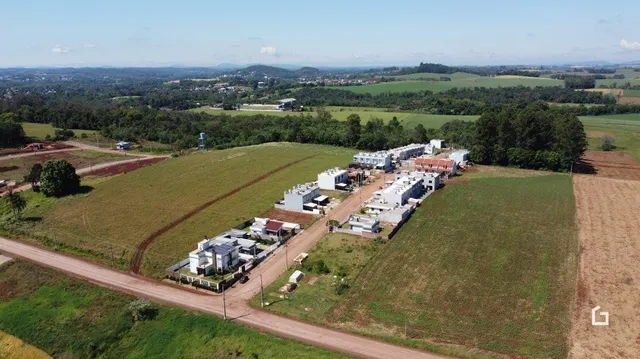 Imagem aérea de uma área de terra com campos e vegetação.