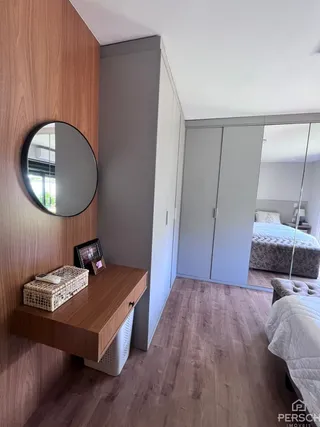 Quarto com painel de madeira e armários em um ambiente interno.