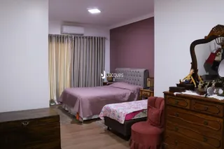 Quarto com cama e cortinas em um imóvel.