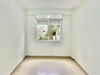 Vista interna de um cômodo com paredes brancas e piso claro.