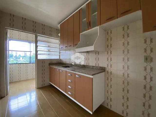 Cozinha com armários de madeira e revestimento de parede.