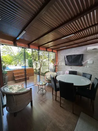 Sala de estar com piso de madeira e acesso ao exterior.