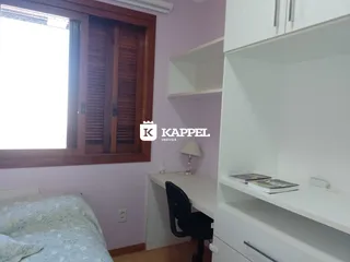 Foto de um quarto com cama e uma escrivaninha branca.