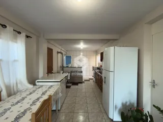 Hall de entrada com piso de cerâmica e geladeira branca.