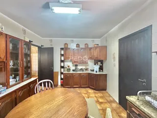 Interior de uma cozinha com armários de madeira e mesa de jantar em Lajeado.