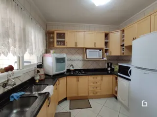 Foto de uma cozinha com armários de madeira e piso cerâmico.
