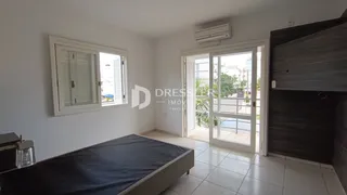 Quarto com janela e acesso a uma porta de vidro que leva a uma área externa.