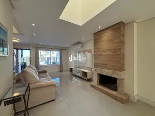 Sala de estar moderna com piso de porcelanato e lareira de pedra.