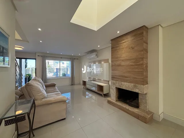 Sala de estar moderna com piso de porcelanato e lareira de pedra.