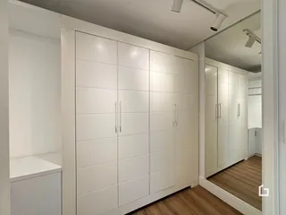 Armários brancos de parede em um ambiente interno.