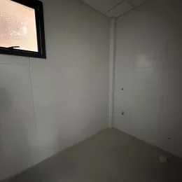 Foto de um corredor interno com paredes brancas.