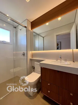 Foto de um banheiro moderno com box de vidro e louças sanitárias.