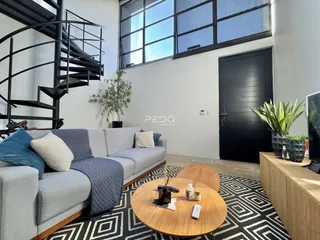 Sala de estar com sofá e janela em imóvel no Brasil.